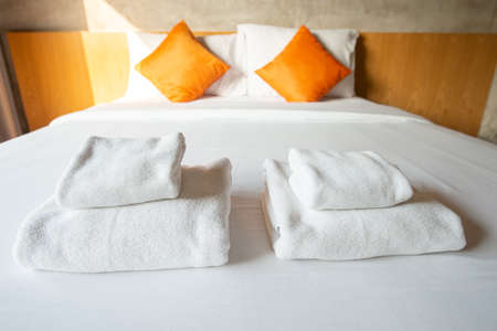 Set of towels on comfortable Double bed in bedroom decoration in cozy style. Conceptual of a room in a home where people sleep.の写真素材