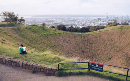 Auckland, New Zealand - March 06 2017: Tourist sitting and relax with the landscape view of the crater of Mt.Eden the iconic volcano landmark in Auckland, New Zealand.のeditorial素材