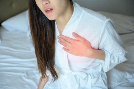 Cropped shot of woman having chest pain or heart attack. Conceptual of heart disease/ chest pain can...