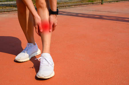 Cropped shot of woman runner suffering pain from Shin splint. It often happens in the front or...
