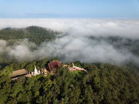 Aerial view of Wat Phra That Doi Phra Chan temple with fog located on the serene top hill in Mae Tha...