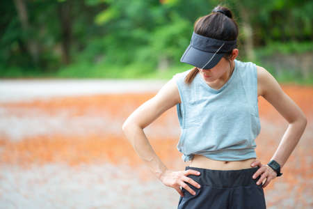 Portrait of young runner woman wearing sportswear, preparing herself before running in the park....