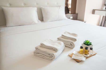Set of hotel amenities (such as towels, shampoo, soap etc) on the bed. Hotel amenities is something of a premium nature provided in addition to the room when renting a room.の写真素材