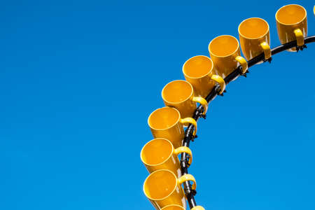 Row of yellow mugs store and hanging on a 'mug tree', a wooden or metal pole mounted on a round base and fitted with pegs to hang mugs by their handles.の写真素材