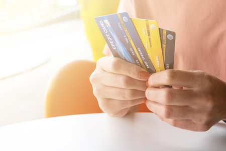 Cropped shot view of female hands holding her credit cards. Credit card lets cardholders borrow...