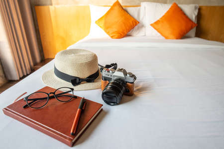 The set of travel equipment arrangement on the bed in cozy hotel, prepare objects for travel. Conceptual of travel and holiday background.の写真素材
