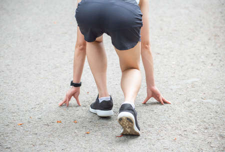 Cropped shot view of athlete runner woman in start position ready for sprint. Conceptual of sport and exercise workout.の写真素材