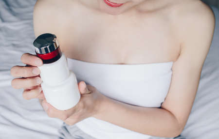 Cropped shot view of young woman holding a stack of moisturizer cream or lotions. Conceptual of beauty and health care skin.の写真素材