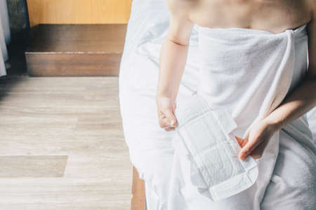 Woman holding sanitary napkins or menstruation pad before wearing it. Women using it during menstruation to avoid damage to clothingの写真素材