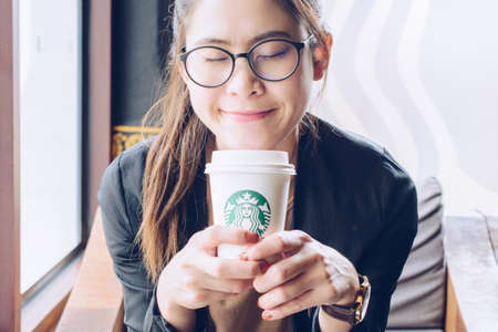 Chiang Mai, Thailand : May-15-2019 : Business Asian woman enjoying her coffee break time with a cup of Starbucks coffee in Starbucks coffee shop.のeditorial素材