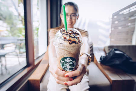 Chiang Mai, Thailand : May-15-2019 : Asian woman holding a cup of Triple mocha frappuccino in...