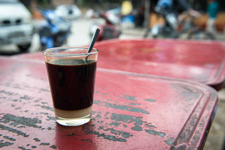 A cup of Thai traditional coffee (other name is Cafe Boran) on the table. It is similar to Americano...