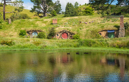 Scenery view of Hobbit holes at the waterfront in Hobbiton movie set in Matamata, New Zealand.のeditorial素材