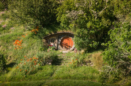 The red door in front of Hobbit hole in Hobbiton movie set in Matamata, New Zealand.のeditorial素材