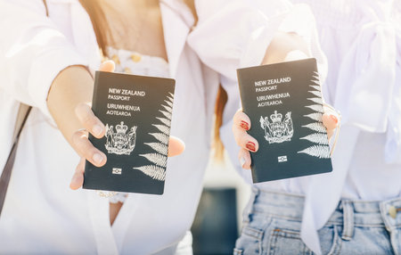 Cropped shot view of young girls holding a New Zealand passport in their hands.