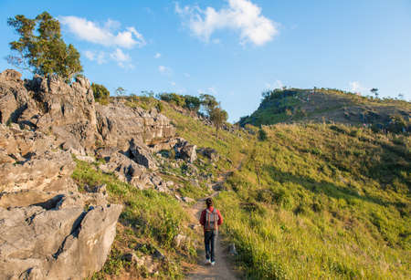 Tourist woman hiking on Doi Pha Tang a high mountain cliff over Thai-Laotian border an area is one...