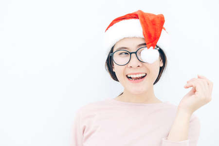 Portrait of happiness Asian woman wearing Santa hat with isolated white wall background. Celebration of Christmas and New year festival concepts.の写真素材