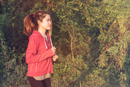 Young woman jogging and running on the rural road. Healthy and Conceptual shot of Healthy and lifestyle of woman while doing workout.の写真素材