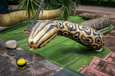 Large snake statue in traditional Thai folk style in Wat Pa Mak Nor temple located on the Widow...