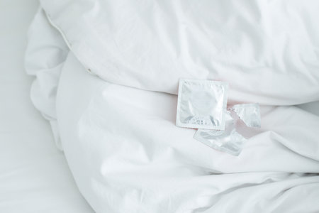 Cropped shot view of condoms on the bed.の写真素材