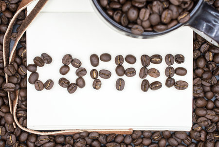 A book with a words of Coffee made by the roasted coffee beans with isolated black background.