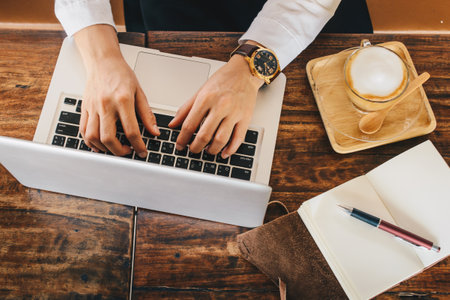 Cropped shot view of businesswoman using her laptop in cafeteria.の写真素材