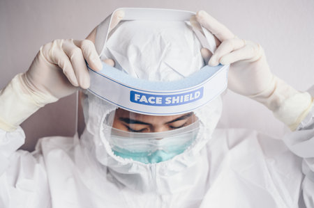 Healthcare worker trying to wearing PPE suit for working in hospitalの写真素材