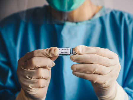 Close up of scientist doctor hand holding a sample test bottle of Covid-19 vaccine. Vaccination is one of the most effective ways to prevent diseases and helps the bodyâs immune syの写真素材