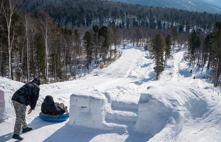 Tourist playing snow tubing in Listvyanka a small town in Irkutsk Oblast on the shores of Lake...