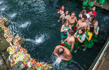 Bali, Indonesia : 14 July 2018 : Group of tourist and Balinese people waiting queue for taking a bath in Pura Tirta Empul the holy spring water temple in Bali, Indonesia.のeditorial素材