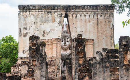 Huge Buddha statue inside a roofed building of Wat Si Chum temple located in the North zone of the Sukhothai Historical Park outside the walled city.の写真素材