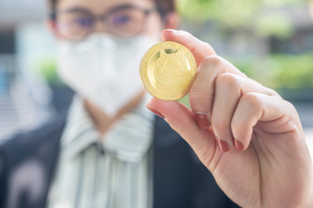 Businesswoman holding a Dogecoin token. Dogecoin is a cryptocurrency, a form of digital money that, much like bitcoin but created as a joke.の写真素材