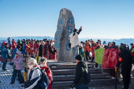 Lijiang, China : March-23-2024 : Crowd of tourist waiting in queue for take a photograph with a symbol rock on Jade dragon snow mountain in Lijiang, in Yunnan province, China.のeditorial素材