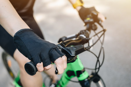 Cropped shot of cyclist hand wearing glove and holding a bicycle brake. Brake is use to reduces the speed of a bicycle from moving.の写真素材