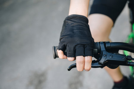 Close-up of cyclist hand wearing glove and holding a bicycle brake. Brake is use to reduces the speed of a bicycle from moving.の写真素材