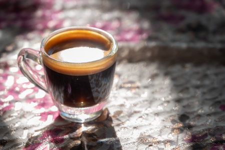 A shot glass of black coffee on table. Black coffee is rich in antioxidants, which can fight cell damage and reduce your risk of serious health conditions.の写真素材
