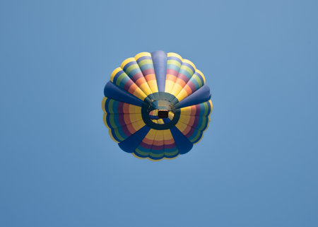 Below view of fancy hot air balloon in flight against the sky. Hot air balloons are aircraft that gain their lift by heating a large contained envelope of air above the ambient temの写真素材
