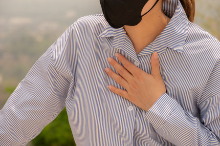 Cropped shot view of businesswoman having respiratory allergy caused of by Bad air pollution (PM2.5). PM2.5 levels meaning the air quality posed a health hazard.の写真素材