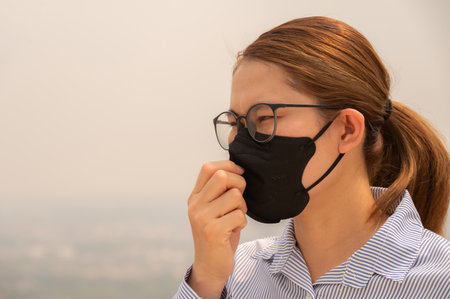 Asian businesswoman coughing becaused of allergy from Bad air pollution (PM2.5). PM2.5 levels meaning the air quality posed a health hazard.の写真素材