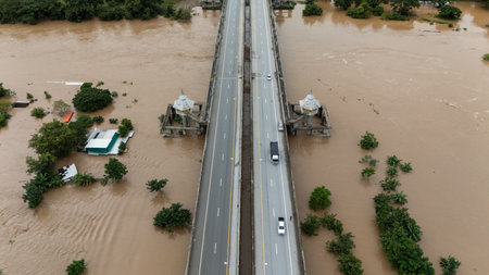 Aerial view of car driving on the bridge while water rising during typhoon Yagi has swept Chiang Rai...