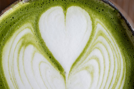Full frame shot of latte art on Matcha latte surface. A matcha latte consists of matcha powder, water, and milk.の写真素材