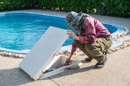 Technician trying to fix swimming pool pumps. The pump keeps the water moving and prevents stagnation while the filter removes debris and contaminants.の写真素材