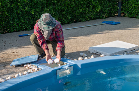 Technician holding chlorine tablets before throwing in swimming pool.の写真素材
