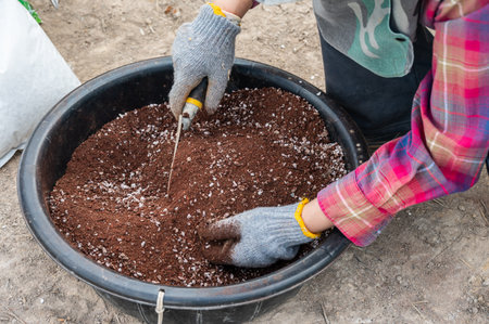 Cropped shot view of gardener using a small shovel for holding an organic mixed rice husk before use as plant fertilizer. rice husk is an organic fertilizer to improve productivityの写真素材