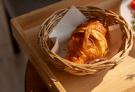 Close up of plain croissants served on wooden table. Croissant is a French buttery, flaky and crescent-shaped bread.の写真素材
