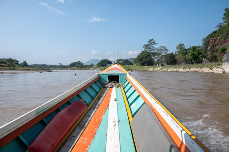 Long-tail boat perspective view while moving on Kok river the river that runs through the city of Chiang Rai province of Thailand. The river originates in the Shan State of Burma.の写真素材