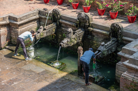 Kathmandu, Nepal : October-14-2023 : Nepali people drinking water from ancient Hiti in Kathmandu, Nepal. A hiti is an ancient and traditional stone water spout system in Kathmandu.のeditorial素材