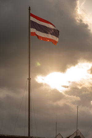 A Thailand national flag on Uttaradit city â€‹â€‹hall blowing by wind during sunset.