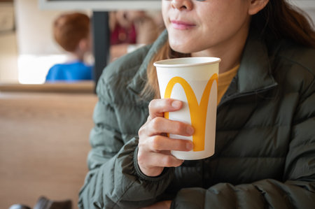 Chiang Rai, Thailand : January-17-2026 : Cropped shot view of Asian woman holding a paper cup of...