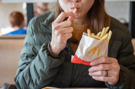 Chiang Rai, Thailand : January-17-2026 : Cropped shot view of Asian woman while eating McDonald's...